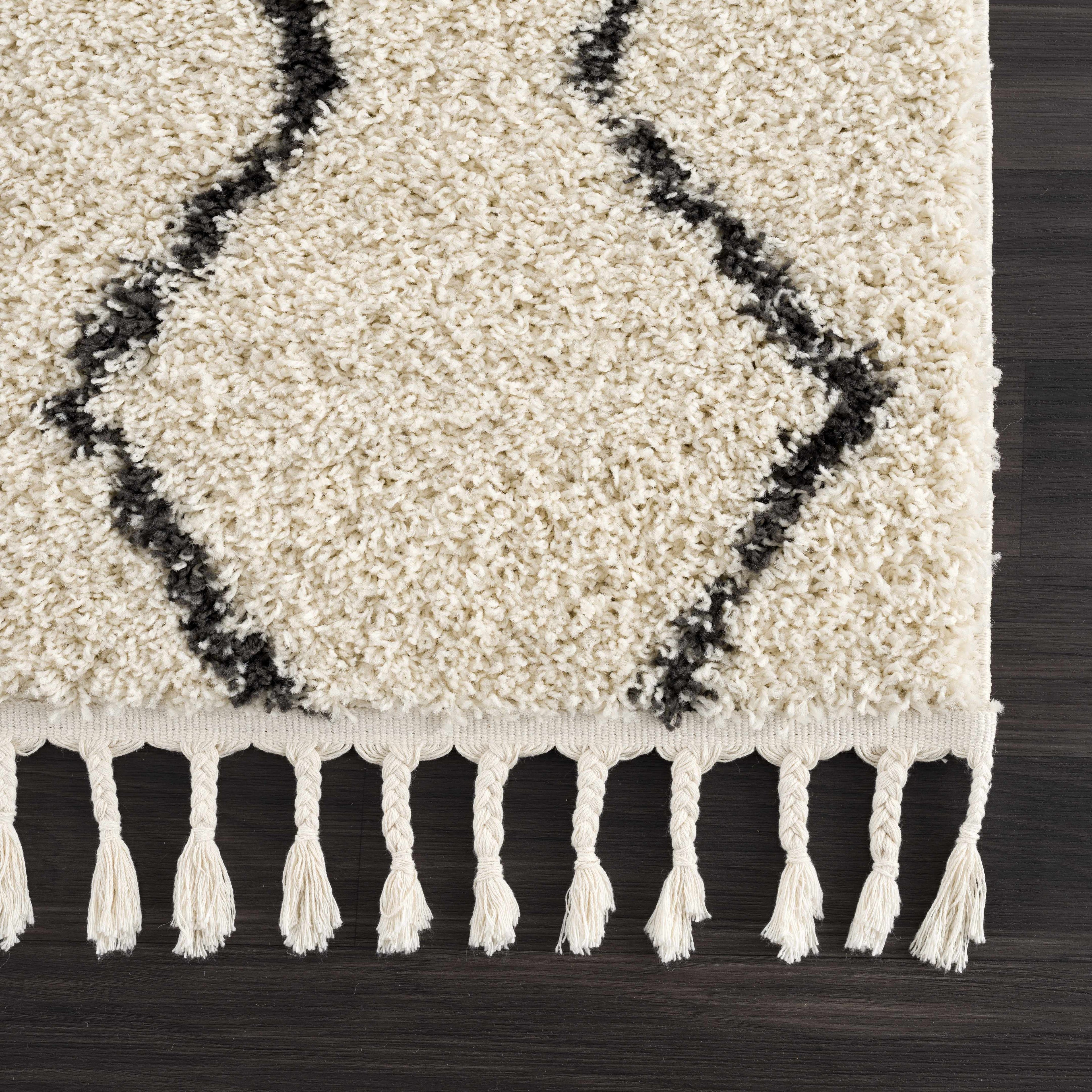 "Fringed edge of the West End Plush Area Rug with black geometric lines, highlighting its bohemian style and soft texture."