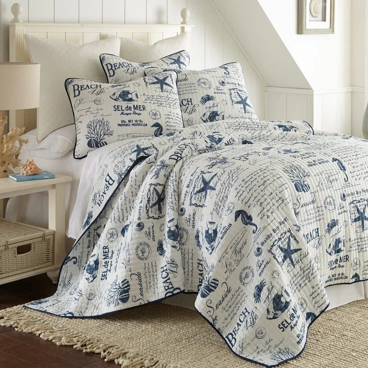 "Beach Life Quilt Set - Nautical Quilt in lightweight cotton featuring coastal motifs like starfish, seahorses, and coral in navy on white. Ideal for coastal bedroom decor."