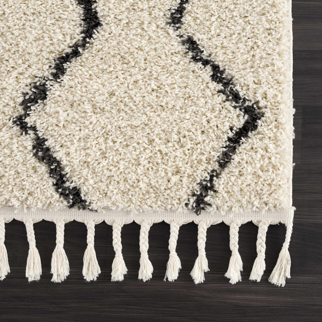 "Fringed edge of the West End Plush Area Rug with black geometric lines, highlighting its bohemian style and soft texture."