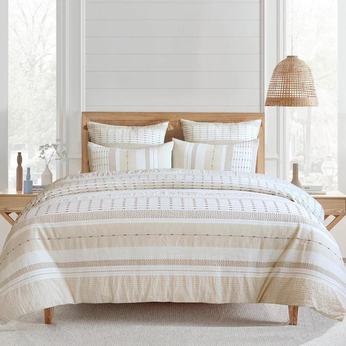 Pickford cotton duvet cover set in beige with coastal jacquard patterns on a wooden bed frame. Ideal for coastal bedroom decor.