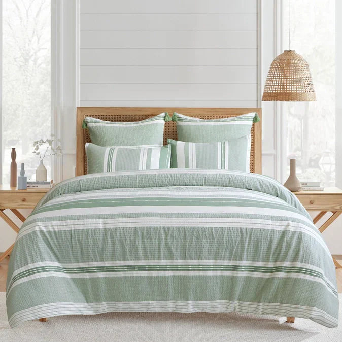 "Pickford Cotton Comforter Set in green with tribal pattern, styled in a coastal bedroom. Features striped design and includes shams and comforter."