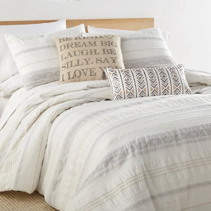 Pickford cotton duvet cover set in taupe with coastal-inspired textured stripes and decorative pillows on a wooden bed frame.