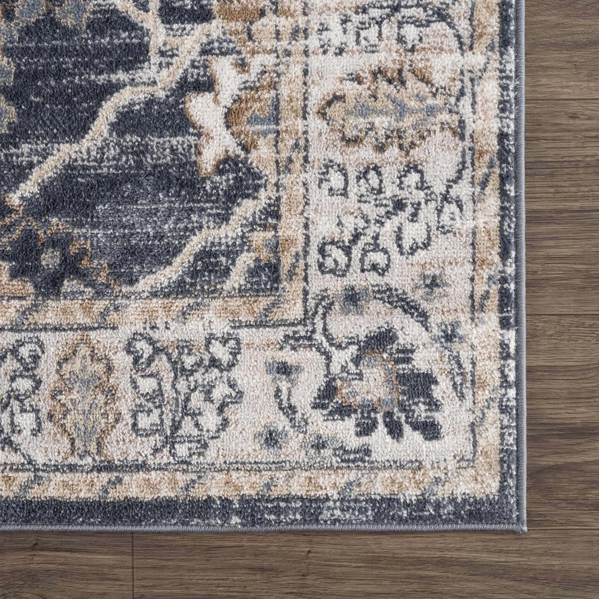 Detailed corner of Scalby Area Rug - Traditional | Hauteloom Styles with floral border and precise weaving in neutral tones.