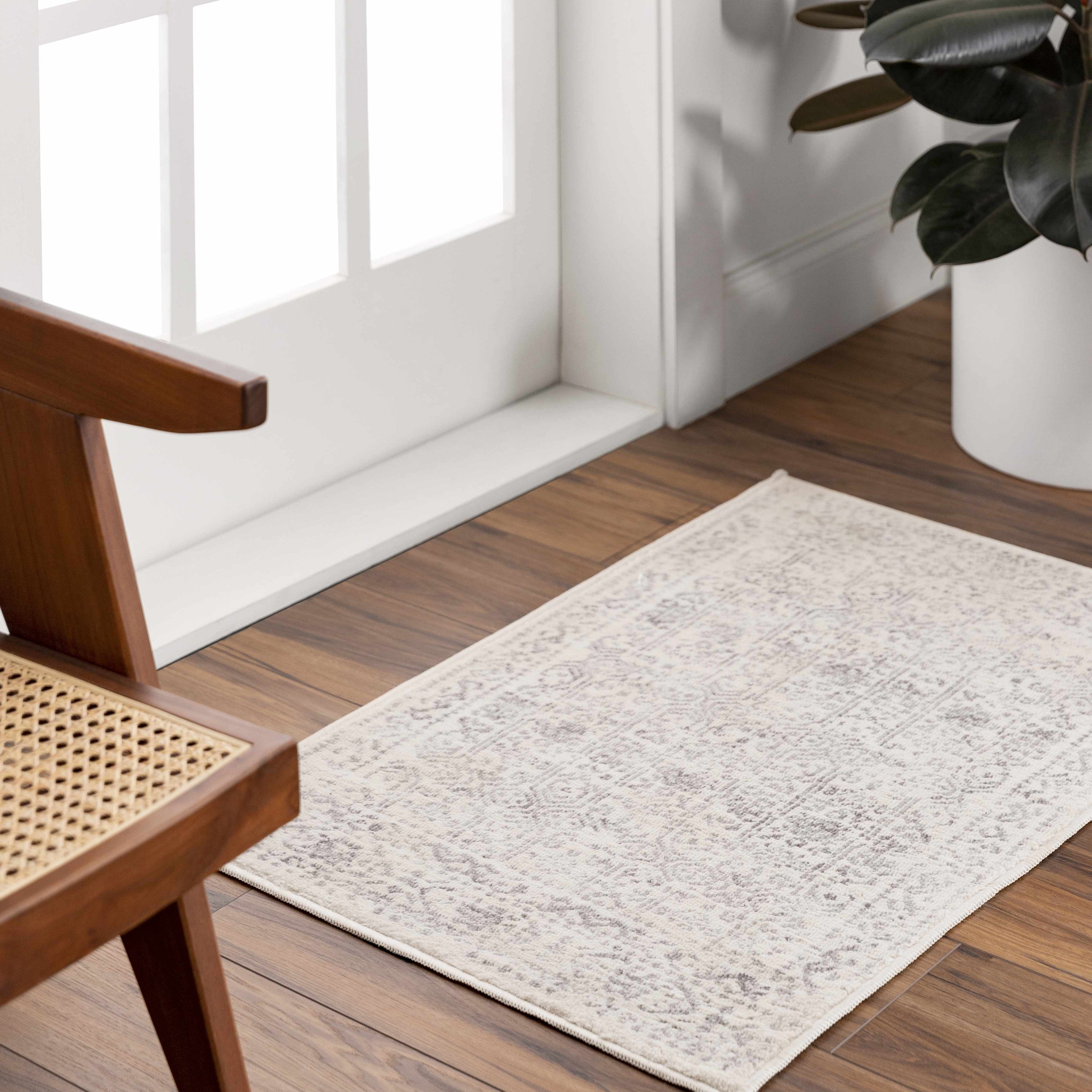 "Small Michie Area Rug in cream and gray placed near a door, ideal for entryways or compact spaces."
